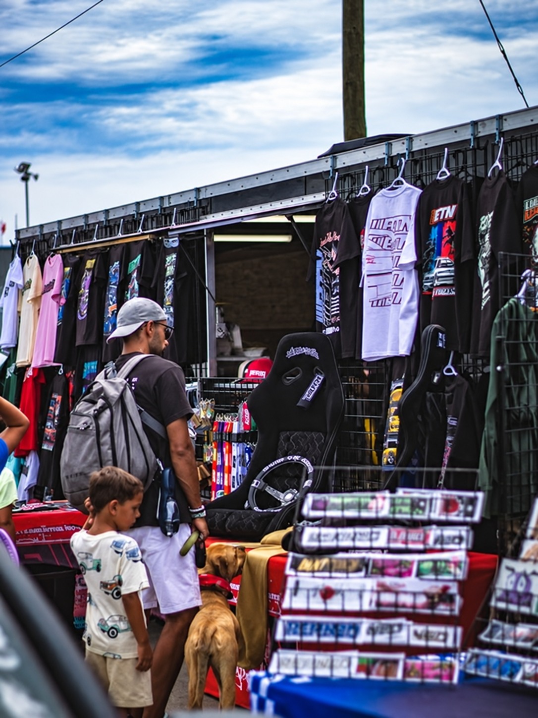 People browsing apparel and accessories at a car event